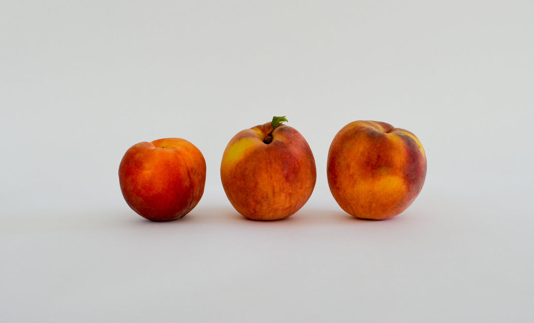 three peaches with different shapes and bumps
